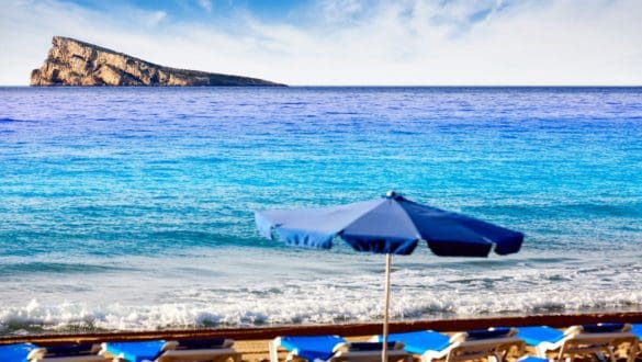 A Glimpse of Paradise: The iconic Benidorm Island beckons in the distance, as seen from the tranquil shores of the beach."