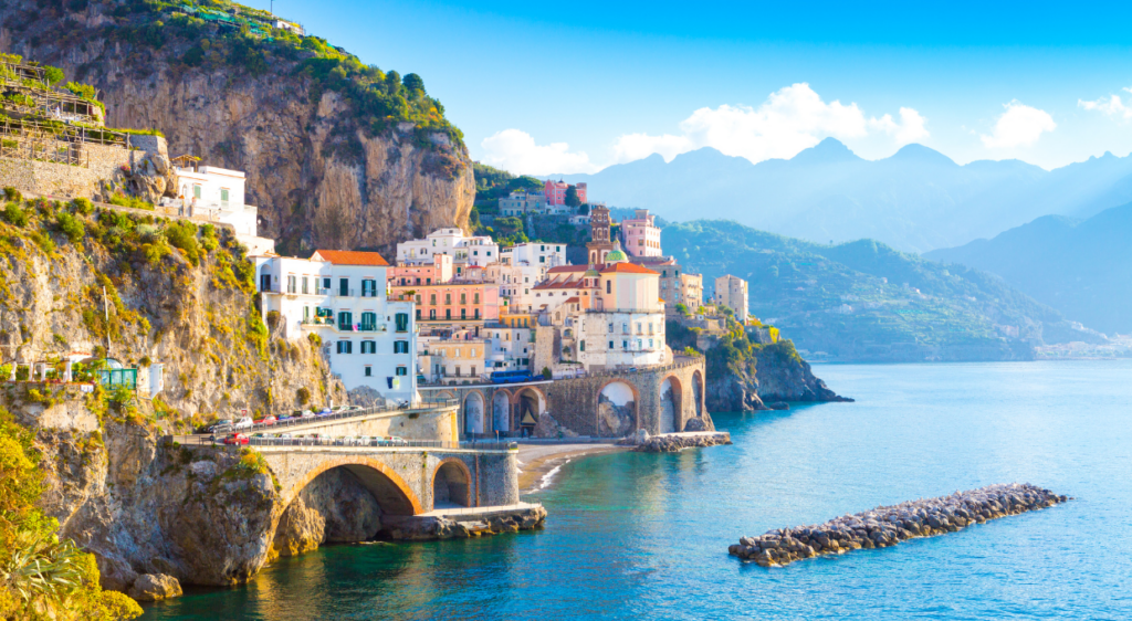 Picturesque view of a coastal village on the Amalfi Coast, with colorful buildings perched on cliffs above the sea.
